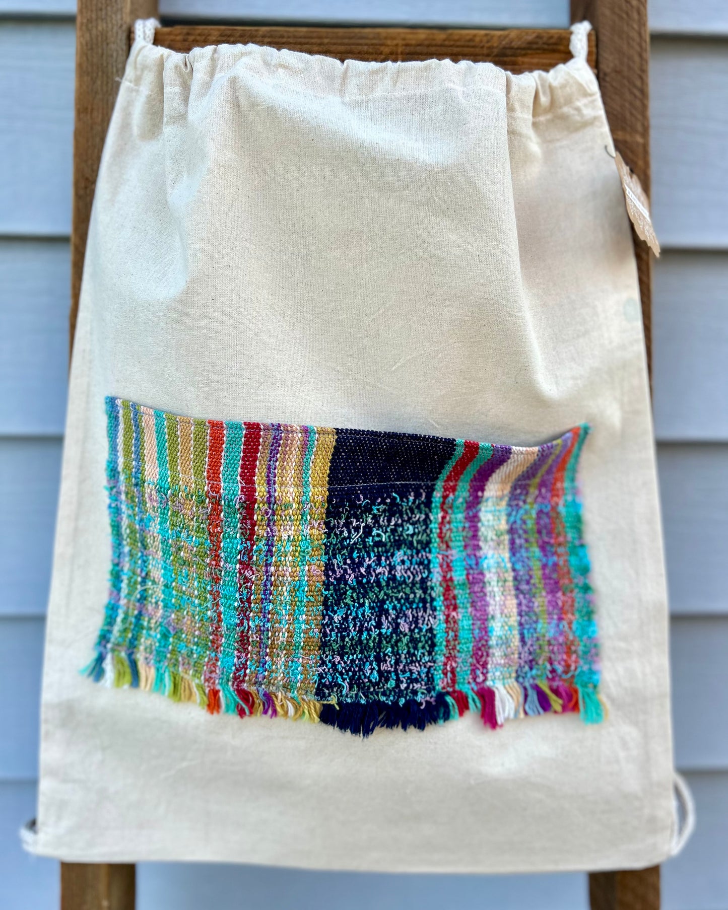 Drawstring canvas backpack with handwoven pocket