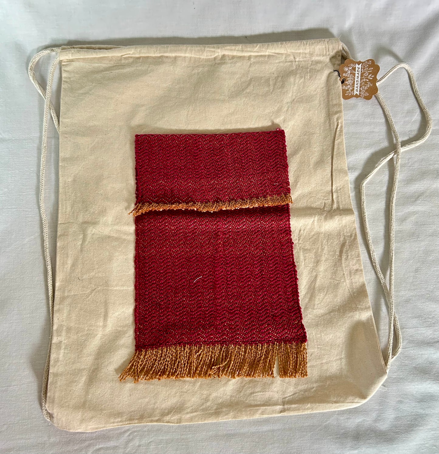Drawstring canvas backpack with handwoven pocket
