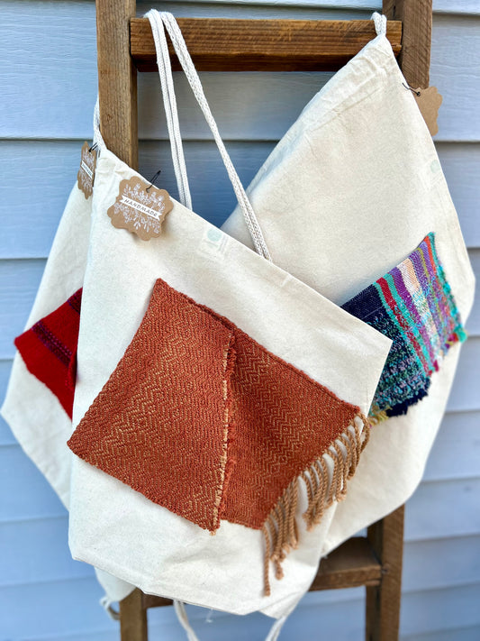 Drawstring canvas backpack with handwoven pocket