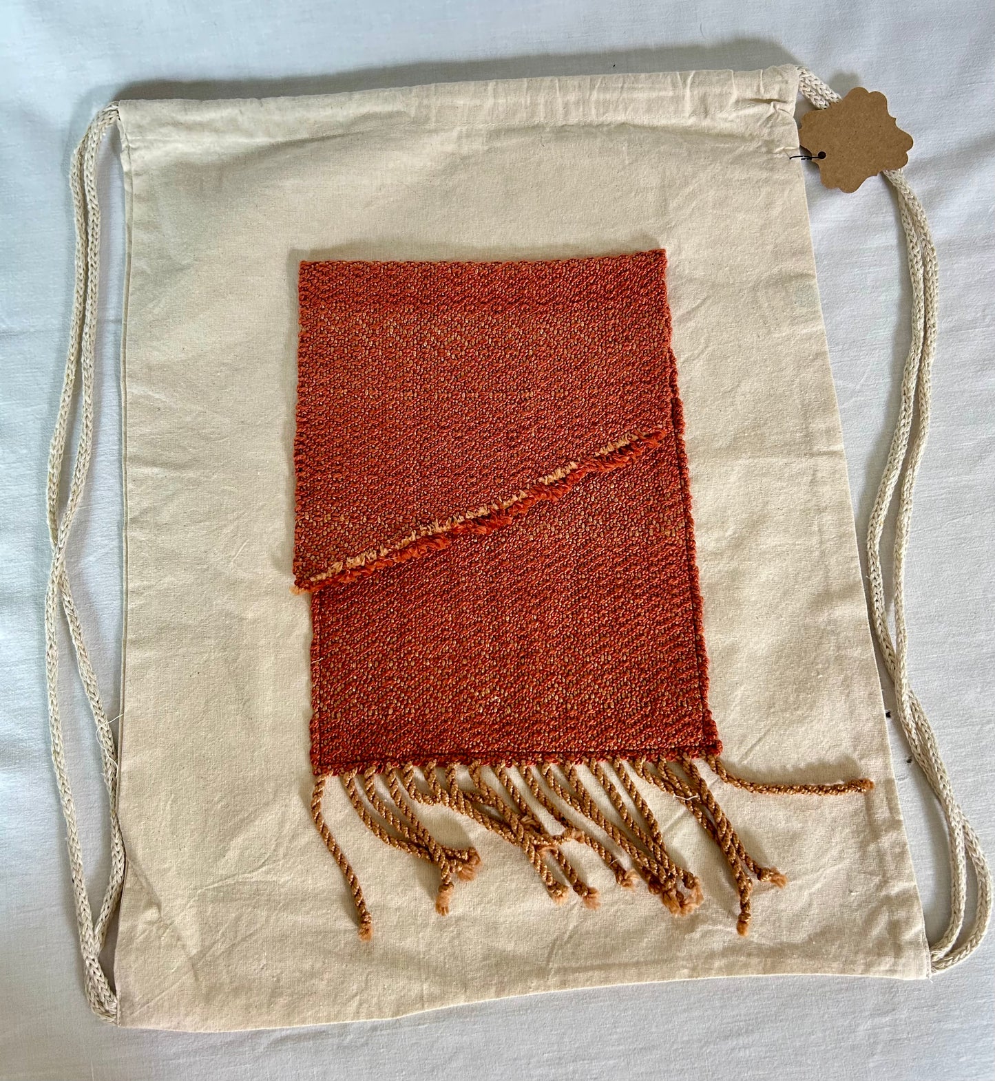 Drawstring canvas backpack with handwoven pocket