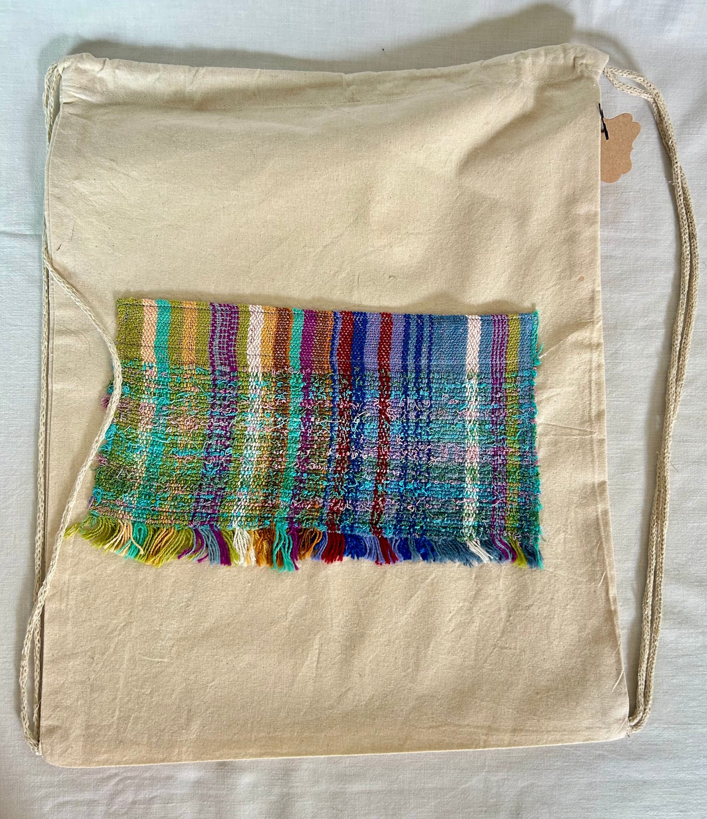 Drawstring canvas backpack with handwoven pocket